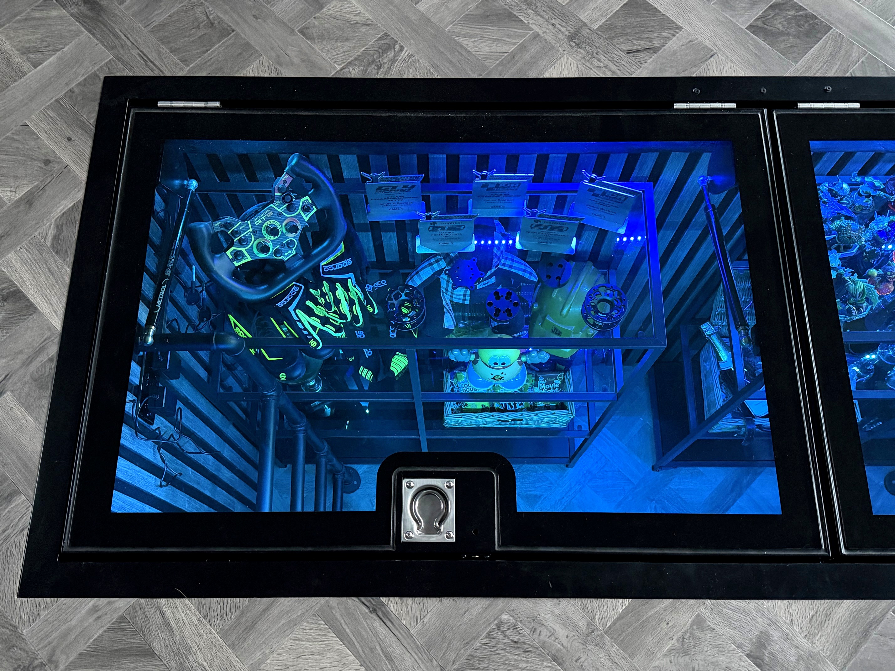 Close up of ring pull handle on hinged glass floor door, LED illuminated display case below, Ashbourne Derbyshire Image title: Close up of ring pull handle on hinged glass floor door, LED illuminated display case below, Ashbourne Derbyshire